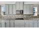 Gray cabinets, granite counters, and a cooktop at 1192 Multiflora Loop, Lutz, FL 33558