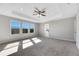 Main bedroom with carpet, ceiling fan and large windows at 1192 Multiflora Loop, Lutz, FL 33558