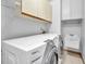 Laundry room with washer, dryer, cabinets, and utility sink at 1570 Bering Ct, Palm Harbor, FL 34683