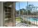 Community pool and surrounding buildings viewed from a screened balcony at 330 Promenade Dr # 207, Dunedin, FL 34698