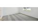Cozy bedroom featuring plush gray carpeting, neutral walls, and natural light streaming through a window at 3952 Big Sky Dr, Spring Hill, FL 34604