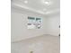Bright, tiled living area with neutral walls and floors, illuminated by recessed lighting and a sunlit window at 3952 Big Sky Dr, Spring Hill, FL 34604