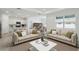 Bright living room with two sofas, modern decor, and an open floor plan leading to the kitchen and dining area at 3952 Big Sky Dr, Spring Hill, FL 34604