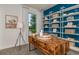 Home office with wooden desk, tall shelving unit, and window with natural light at 3952 Big Sky Dr, Spring Hill, FL 34604