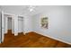 Bedroom with hardwood floors, ceiling fan, and access to closet at 7302 N Highland Ave, Tampa, FL 33604