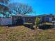 Tan single-story house with carport, white fence, and well-maintained landscaping at 7304 36Th N Ave, St Petersburg, FL 33710