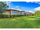 Landscaped backyard with grassy lawn and home view at 8376 Catamaran Cir, Lakewood Ranch, FL 34202