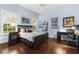 Bright bedroom with dark wood floors, a queen bed, and built-in desk at 8376 Catamaran Cir, Lakewood Ranch, FL 34202
