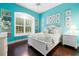 Charming bedroom with white bed, window seat, and teal walls at 8376 Catamaran Cir, Lakewood Ranch, FL 34202