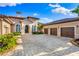 Luxury home with three-car garage, lush landscaping, and a large driveway at 8376 Catamaran Cir, Lakewood Ranch, FL 34202