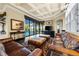 Living room with hardwood floors, leather sofas, and access to the pool area at 8376 Catamaran Cir, Lakewood Ranch, FL 34202