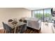 Bright dining area with glass table and grey chairs, near balcony at 900 Cove Cay Dr # 2B, Clearwater, FL 33760