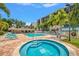 Community pool and spa area with lounge chairs and lush landscaping at 900 Cove Cay Dr # 2B, Clearwater, FL 33760