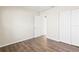 Empty bedroom with wood-look laminate flooring, neutral walls, and white closet doors at 9201 40Th N Way, Pinellas Park, FL 33782