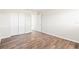 Empty bedroom with wood-look laminate flooring, neutral walls, and white closet doors at 9201 40Th N Way, Pinellas Park, FL 33782