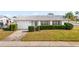 Charming single-story home with a white exterior, attached garage, and landscaped yard at 9201 40Th N Way, Pinellas Park, FL 33782