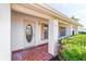 Inviting front entry with an oval glass door, red tiled porch, and white brick columns at 9201 40Th N Way, Pinellas Park, FL 33782