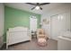 Bedroom featuring a crib, rocker, and built-in shelving at 1003 Tidal Rock Ave, Ruskin, FL 33570