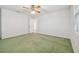 Spacious bedroom with green carpet, ceiling fan and access to hallway at 11114 Lake Sassa Dr, Thonotosassa, FL 33592