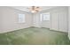 Bright bedroom with green carpet, ceiling fan, and double closets at 11114 Lake Sassa Dr, Thonotosassa, FL 33592