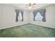 Spacious bedroom with light-colored walls and carpeting, featuring two windows with blue curtains at 11114 Lake Sassa Dr, Thonotosassa, FL 33592