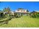 Two-story house with a green lawn, and mature trees in the front yard at 11114 Lake Sassa Dr, Thonotosassa, FL 33592