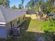 Backyard with gray house exterior, grassy area, and trees at 116 S Hale Ave, Tampa, FL 33609