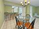 Dining area with glass-top table, four chairs, and kitchen bar at 1515 Pinellas Bayway S # 40, St Petersburg, FL 33715