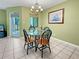 Dining area with glass-top table and four chairs, and access to balcony at 1515 Pinellas Bayway S # 40, St Petersburg, FL 33715