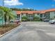 Condo building with Spanish tile roofs, parking, and mature landscaping at 1515 Pinellas Bayway S # 40, St Petersburg, FL 33715
