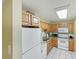 White appliances and wood cabinets in this galley kitchen at 1515 Pinellas Bayway S # 40, St Petersburg, FL 33715