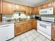 Kitchen with wood cabinets, granite countertops, and white appliances at 1515 Pinellas Bayway S # 40, St Petersburg, FL 33715