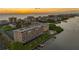 Aerial view of building, pool, dock, and waterway at sunset at 19451 Gulf Blvd # 806, Indian Shores, FL 33785