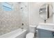 Clean bathroom with geometric tile shower, white toilet, and gray vanity at 2420 28Th N St, St Petersburg, FL 33713