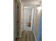 Hallway with wood laminate floors leading to a bedroom; doorway to bathroom with towel rack at 4500 37Th S St # 27, St Petersburg, FL 33711