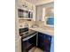 Galley kitchen with new stainless steel microwave and electric range plus black dishwasher at 4500 37Th S St # 27, St Petersburg, FL 33711