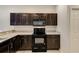 Dark wood cabinets, granite counters, and built-in microwave at 4781 Vignette Way, Sarasota, FL 34240