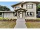 Two-story house with gray exterior, landscaping, and walkway at 701 N Warnell St, Plant City, FL 33563