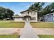 Two-story house with a gray exterior, landscaping, and walkway at 701 N Warnell St, Plant City, FL 33563