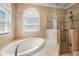 Spa-like bathroom with soaking tub, walk-in shower, and window at 7416 S Morton St, Tampa, FL 33616