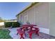 Red picnic table on a paved patio next to screened enclosure at 11341 Flora Springs Dr, Riverview, FL 33579