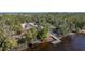 Aerial view of a charming waterfront home with a private dock and lush landscaping at 15435 27Th E Ct, Parrish, FL 34219