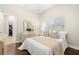 Bright bedroom with a queen-size bed and hardwood floors at 15435 27Th E Ct, Parrish, FL 34219