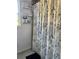 Bathroom with a floral shower curtain and storage at 2415 Sutton Pl, Spring Hill, FL 34608