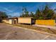 Tan carport with a yellow wood fence at 2621 13Th N St, St Petersburg, FL 33704