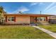 Tan brick ranch home with red shutters, landscaped lawn, and walkway at 2621 13Th N St, St Petersburg, FL 33704