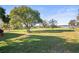Spacious grassy backyard with large shade tree and lake view at 3111 Lewis Rd, Dover, FL 33527