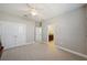 Upstairs bedroom with double doors leading to the bathroom and a ceiling fan at 32076 Wenlock Loop, Wesley Chapel, FL 33543