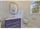 A half bath features marble floors and an elegant purple cabinet with gold accents at 3509 W Leona St, Tampa, FL 33629