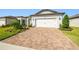 Landscaped front yard with a paver driveway leading to a two-car garage at 6098 Shorebird Br, Land O Lakes, FL 34638